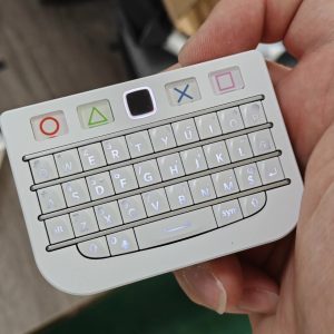 White BBQ10KBD Pro mini keyboard held in one hand